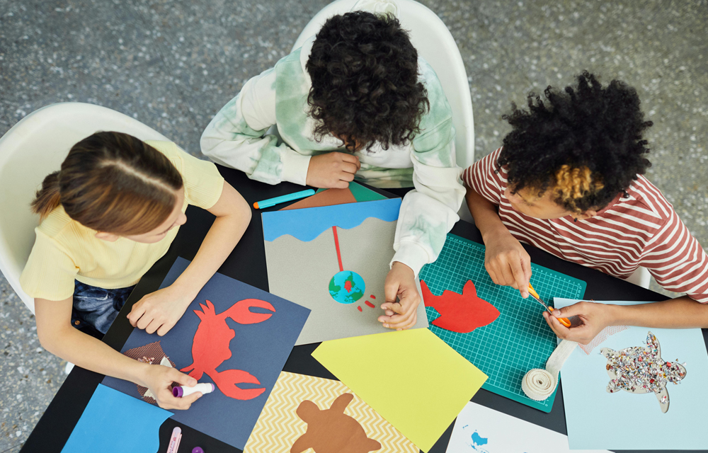 top view of 3 kids working on art